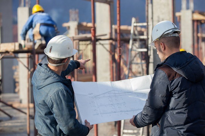 Construction worker checking crane location site bac